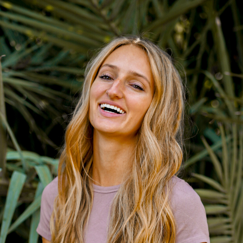 Marisa Flint, Director of Investor Relations at Lukrom, smiling outdoors with a leafy background