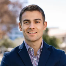 Mike Susi, Director of Lending at Lukrom, smiling outdoors with a blurred background